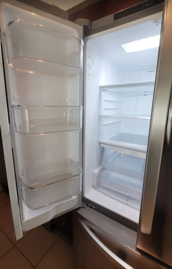 Empty refrigerator interior with sanitized shelves and clear door bins